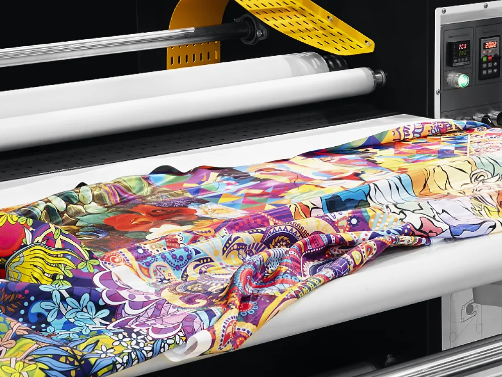 Vibrantly printed fabric passing through an industrial digital textile printing machine.