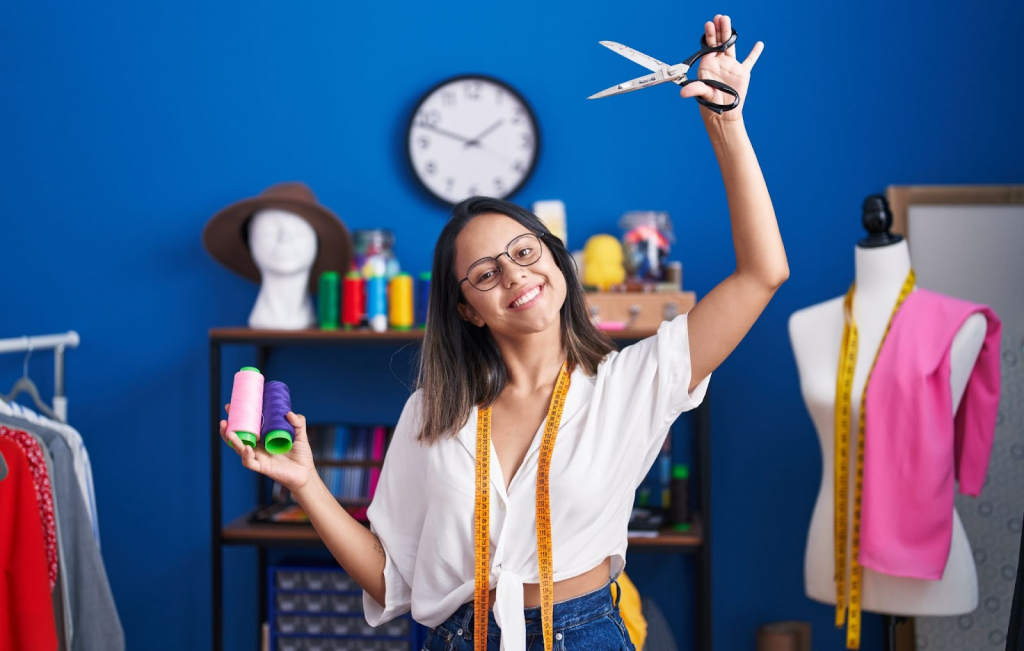 Fashion stylist working with sewing tools and mannequin in a creative workspace – Top fashion jobs with high salaries in 2025