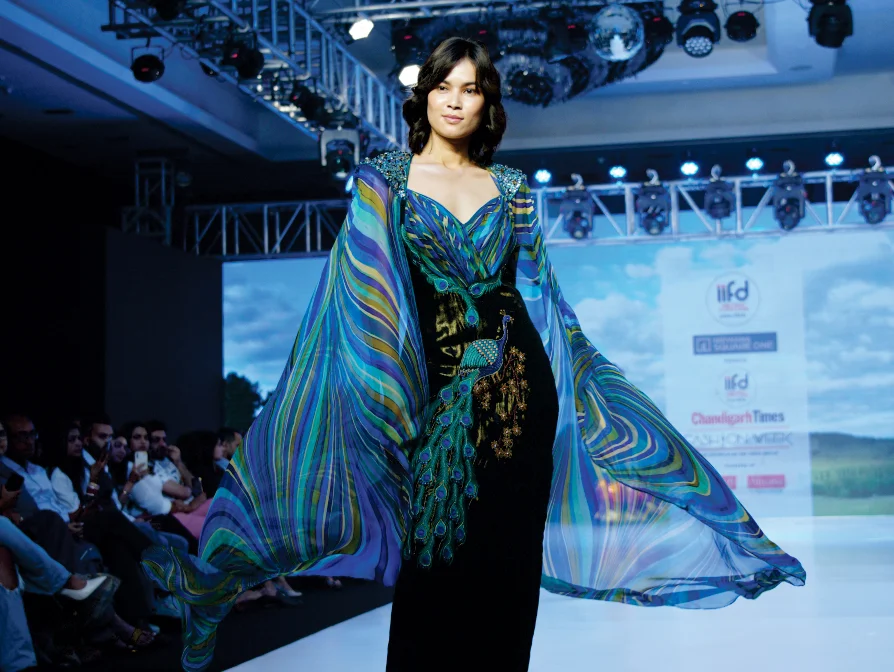 Fashion show runway at International Institute of Fashion Design IIFD Hyderabad featuring designer model wearing multicolored striped outfit on stage