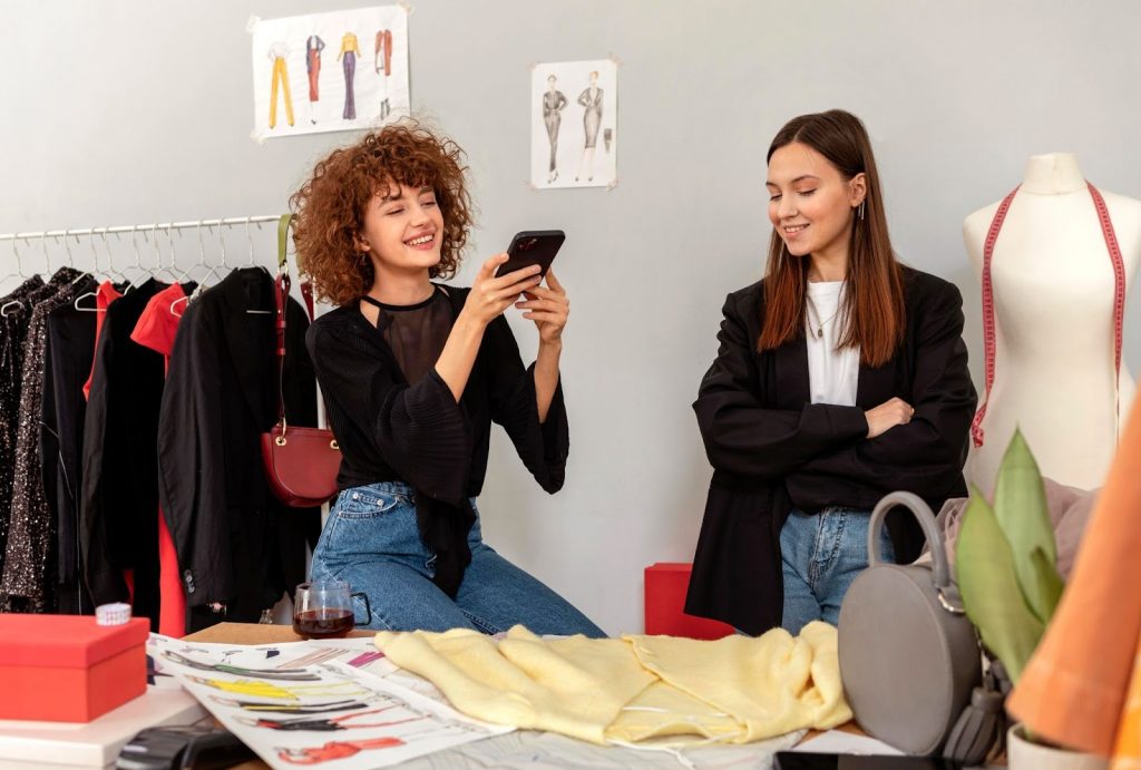 Happy woman on a couch using a laptop for online research or e-commerce, symbolizing the digital aspects of a fashion marketing and merchandising course for professionals.