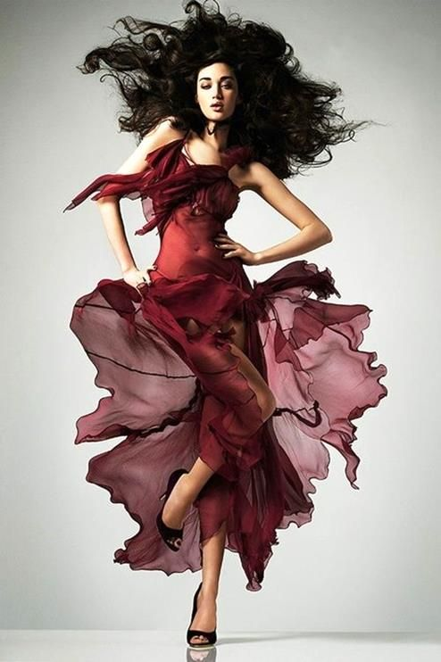 Dramatic shot of a model in a flowing red dress, showcasing the high-end visuals related to a fashion photography course for creative professionals in India.